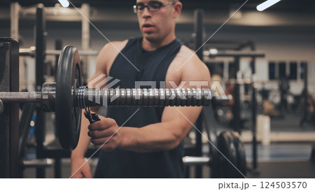 The male athlete arab changes the weight on the barbell. The male athlete arab changes the weight on the barbell. 124503570