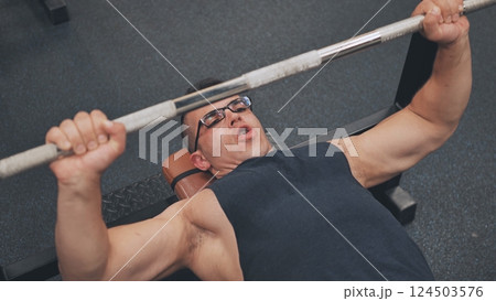 An Arab man pumps his chest in the gym. 124503576