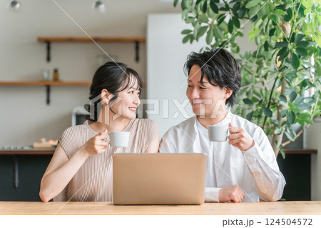 家のリビング・ダイニングでくつろぐ仲良しの若い日本人夫婦 家のリビング・ダイニングでくつろぐ仲良しの若い日本人夫婦 124504572