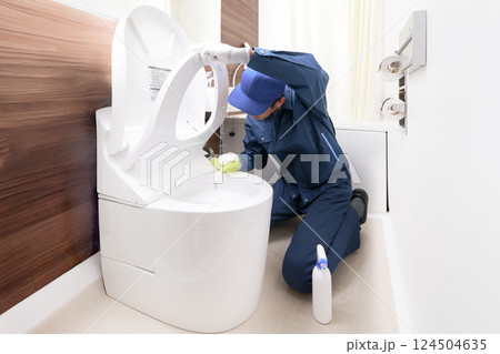 トイレの清掃をするハウスクリーニングの男性作業員 トイレの清掃をするハウスクリーニングの男性作業員 124504635