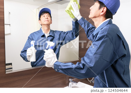 洗面所の清掃をする作業服の男性スタッフ 124504644