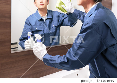 洗面所の清掃をする作業服の男性スタッフ 洗面所の清掃をする作業服の男性スタッフ 124504645