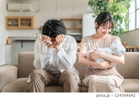 赤ちゃんの子育て・育児で悩む男性と笑顔の女性（夫婦・カップル） 124504842