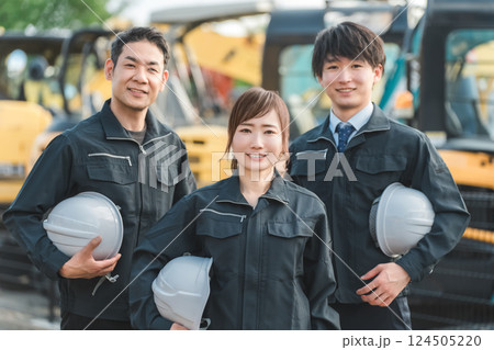 重機の前にいる作業着姿の建設業・建築業の作業員男女 124505220