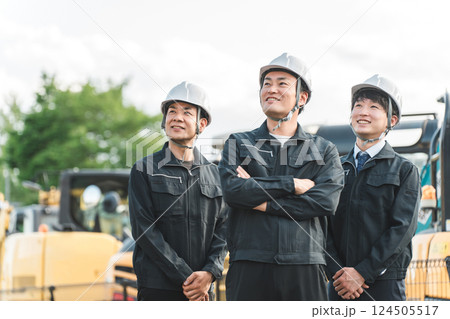 重機の前にいる作業着姿の建設業・建築業の作業員男性ビジネスマン 124505517
