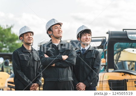 重機の前にいる作業着姿の建設業・建築業の作業員男性ビジネスマン 重機の前にいる作業着姿の建設業・建築業の作業員男性ビジネスマン 124505519