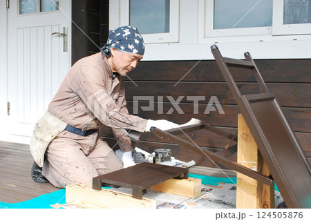 看板に塗装をする中年男性 124505876