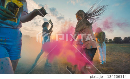 Young people celebrating holi festival, throwing colored powder at sunset, having fun together Young people celebrating holi festival, throwing colored powder at sunset, having fun together 124506514