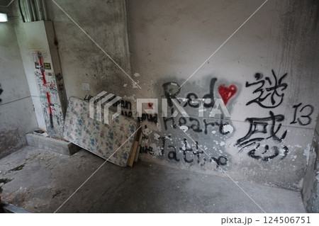 廃墟や路地裏へと続く階段の壁の落書きとゴミの散らばる暗い地面 124506751