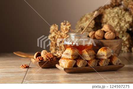 Baklava with walnuts and honey on a beige background. Baklava with walnuts and honey on a beige background. 124507275