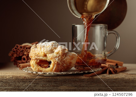 Viennese strudel and black coffee on an old wooden table. 124507296
