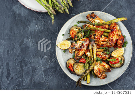 Grilled chicken wings with green asparagus. 124507535