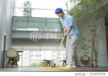 ビル清掃イメージ　フロアのモップかけをする男性清掃スタッフ 124507939