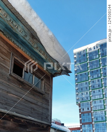 Old wood house against modern city building 124508144