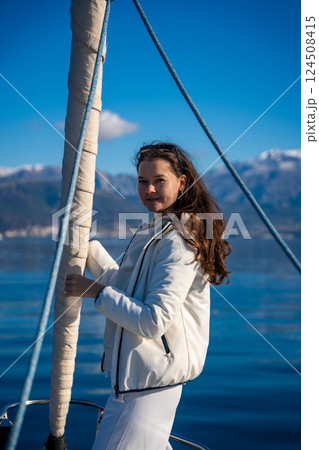 Portrait of young woman on bow of the yacht during sailing in the morning in winter time in Adriatic sea, yacht life and yachting concept Portrait of young woman on bow of the yacht during sailing in the morning in winter time in Adriatic sea, yacht life and yachting concept 124508415