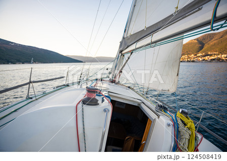 Yacht sailing in Adriatic sea. Close-up view of the deck, mast and sails. Yachting concept Yacht sailing in Adriatic sea. Close-up view of the deck, mast and sails. Yachting concept 124508419