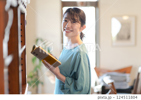 本棚の前で本を読む女性 124511804
