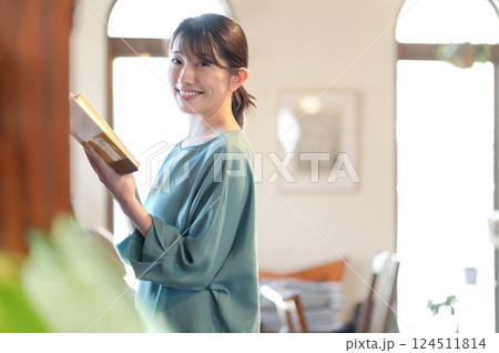本棚の前で本を読む女性 124511814