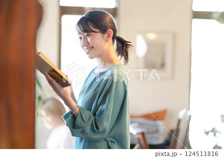 本棚の前で本を読む女性 124511816