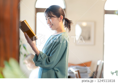 本棚の前で本を読む女性 124511818