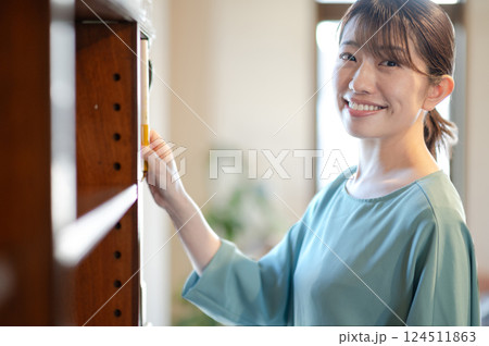 本棚から本を取る女性 124511863