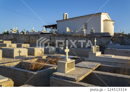 Chapel and crosses in a Greek cemetery at dawn, sunny summer day, Crete 124513314