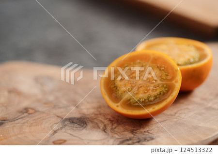 Lulo fruit sliced in halves on olive wood board on kitchen countertop Lulo fruit sliced in halves on olive wood board on kitchen countertop 124513322