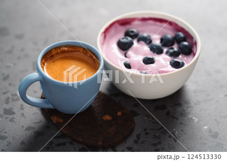 Blueberry yogurt with whole berries and cup of fresh espresso on concrete background 124513330