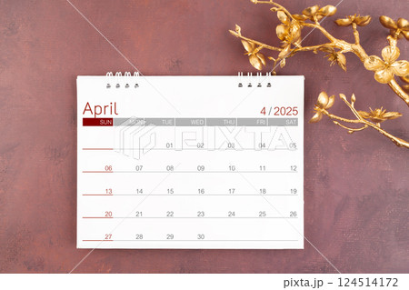 Desk calendar for April 2025 with gold color cherry blossoms branch. 124514172