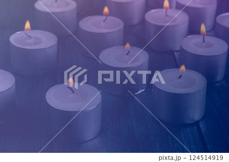 Tea light candles on a dark background, many lights in the dark Tea light candles on a dark background, many lights in the dark 124514919