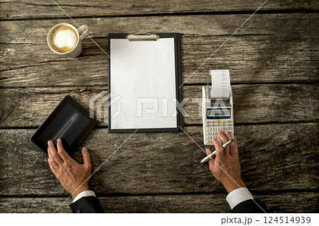 Businessman with Devices and Paper on Table Businessman with Devices and Paper on Table 124514939
