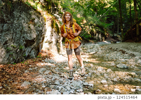 Traveler woman walking along hiking trail through forest thicket in the mountains. Active lifestyle. Traveler woman walking along hiking trail through forest thicket in the mountains. Active lifestyle. 124515464