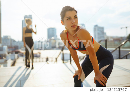 Two women in sportive clothes have fitness day outdoors together. Active life, healthy lifestyle. Two women in sportive clothes have fitness day outdoors together. Active life, healthy lifestyle. 124515767