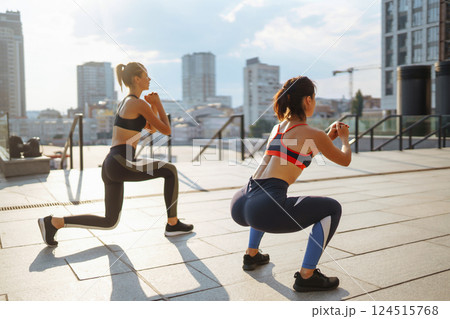 Two women in sportive clothes have fitness day outdoors together. Active life, healthy lifestyle. 124515768