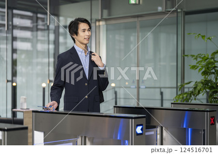 オフィスビルのセキュリティゲートを通る若いビジネスマン 124516701