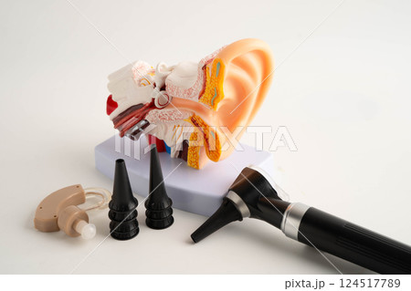 Otoscope with ear model for otolaryngologist or ENT physician doctor examining senior patient ear, hearing loss problem. 124517789