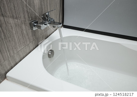 shower bath faucet is turned on and amount of water flows out added fill to the bathtub. shower bath faucet is turned on and amount of water flows out added fill to the bathtub. 124518217