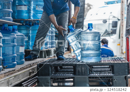 worker transfer drinking water bottle from production plant line to truck for customer market worker transfer drinking water bottle from production plant line to truck for customer market 124518242