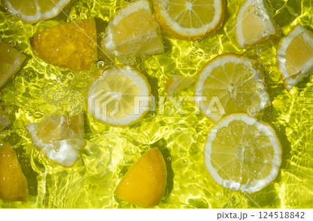 Vibrant yellow lemon pieces floating in motion water 124518842