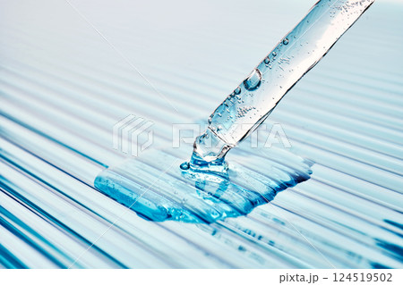 Serum in a pipette on a blue ribbed background. 124519502