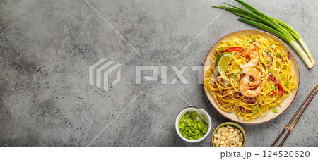 Pad thai noodles with shrimps, peanuts and lime on a plate top view, dish of Thailand. Space for text Pad thai noodles with shrimps, peanuts and lime on a plate top view, dish of Thailand. Space for text 124520620