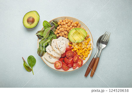 Healthy bowl with chicken breast, avocado, chickpeas, corn and tomatoes on grey background top view. Diet and healthy food concept 124520638