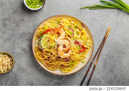Pad thai noodles with shrimp, peanuts and lime on grey background, dish of Thailand 124520643