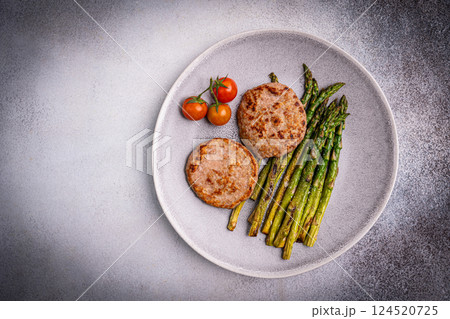 Grilled turkey burgers or cutlets and green asparagus Grilled turkey burgers or cutlets and green asparagus 124520725