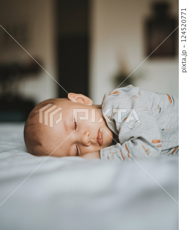 Side view of European child sleeping peacefully in bed with blurred room in background 124520771