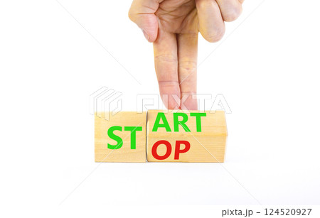 Start or stop symbol. Concept words Start or Stop on beautiful wooden block. Beautiful white table white background. Businessman hand. Business start or stop concept. Copy space. 124520927