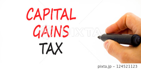 Capital gains tax symbol. Concept words Capital gains tax on beautiful white paper. Beautiful white background. Businessman hand with pen. Business and capital gains tax concept. Copy space. 124521123