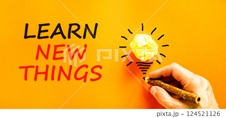 Learn new things symbol. Concept words Learn new things on beautiful orange paper. Beautiful orange background. Businessman hand. Light bulb. Business motivational learn new things concept. Copy space 124521126