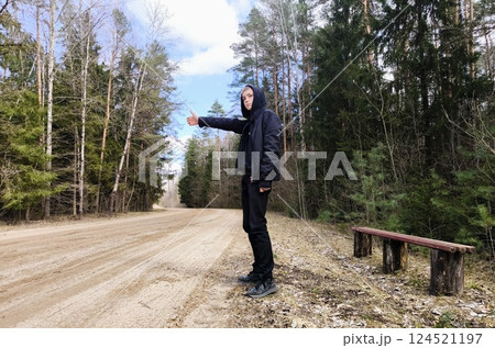 Travel Concept. Guy tries to stop car, asks for help with thumbs up 124521197