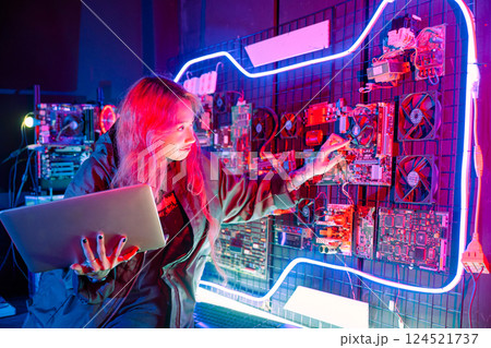 Cyber security. Software engineer holding laptop computer at data center checking hardware, Hacker woman service in server room, check circuit board with many small components 124521737